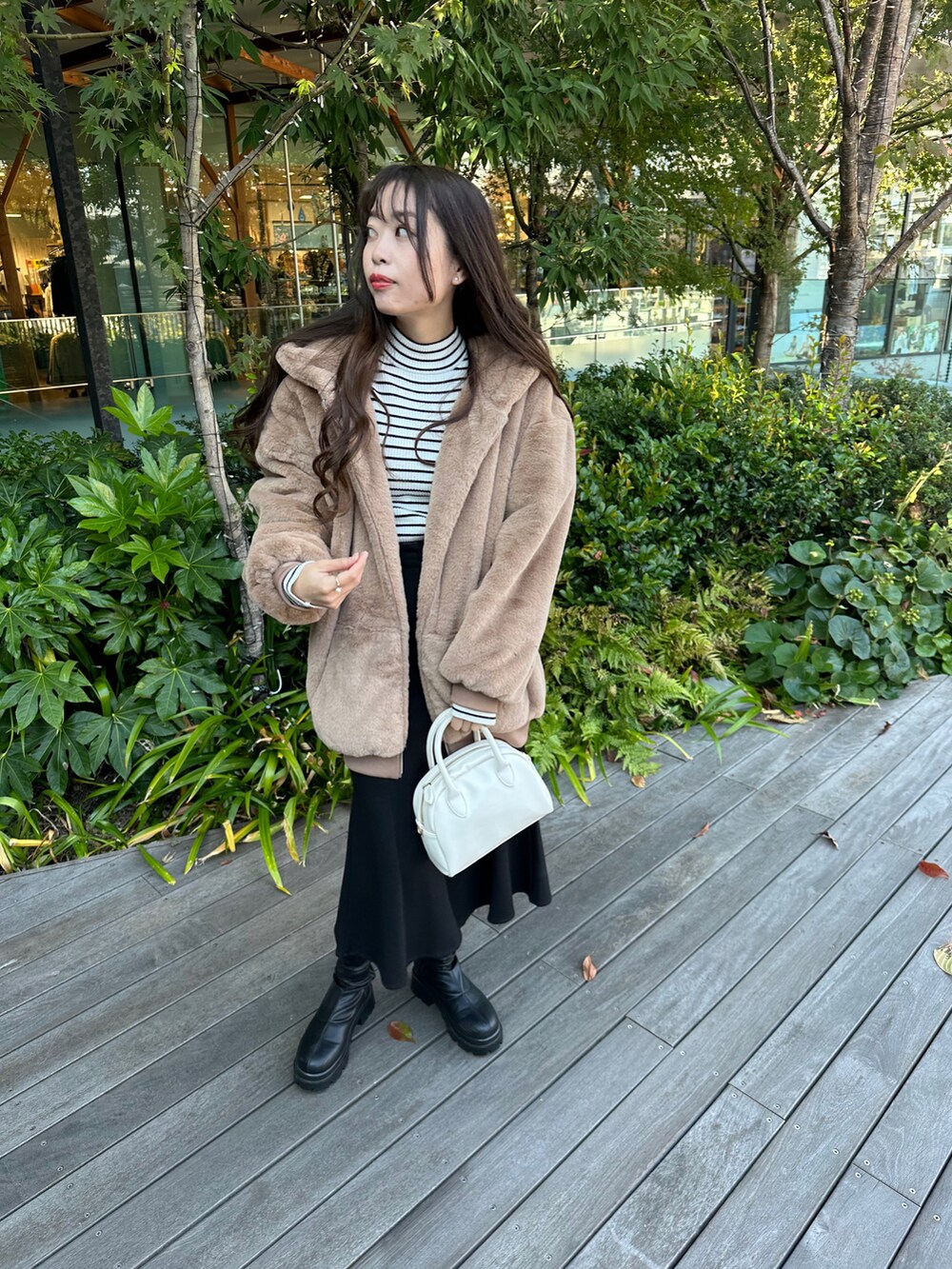 ブラック系のニット/セーター、ブラウン系のブルゾン、ブラック系のスカートを着用したレディースの秋コーディネートの2枚目の写真