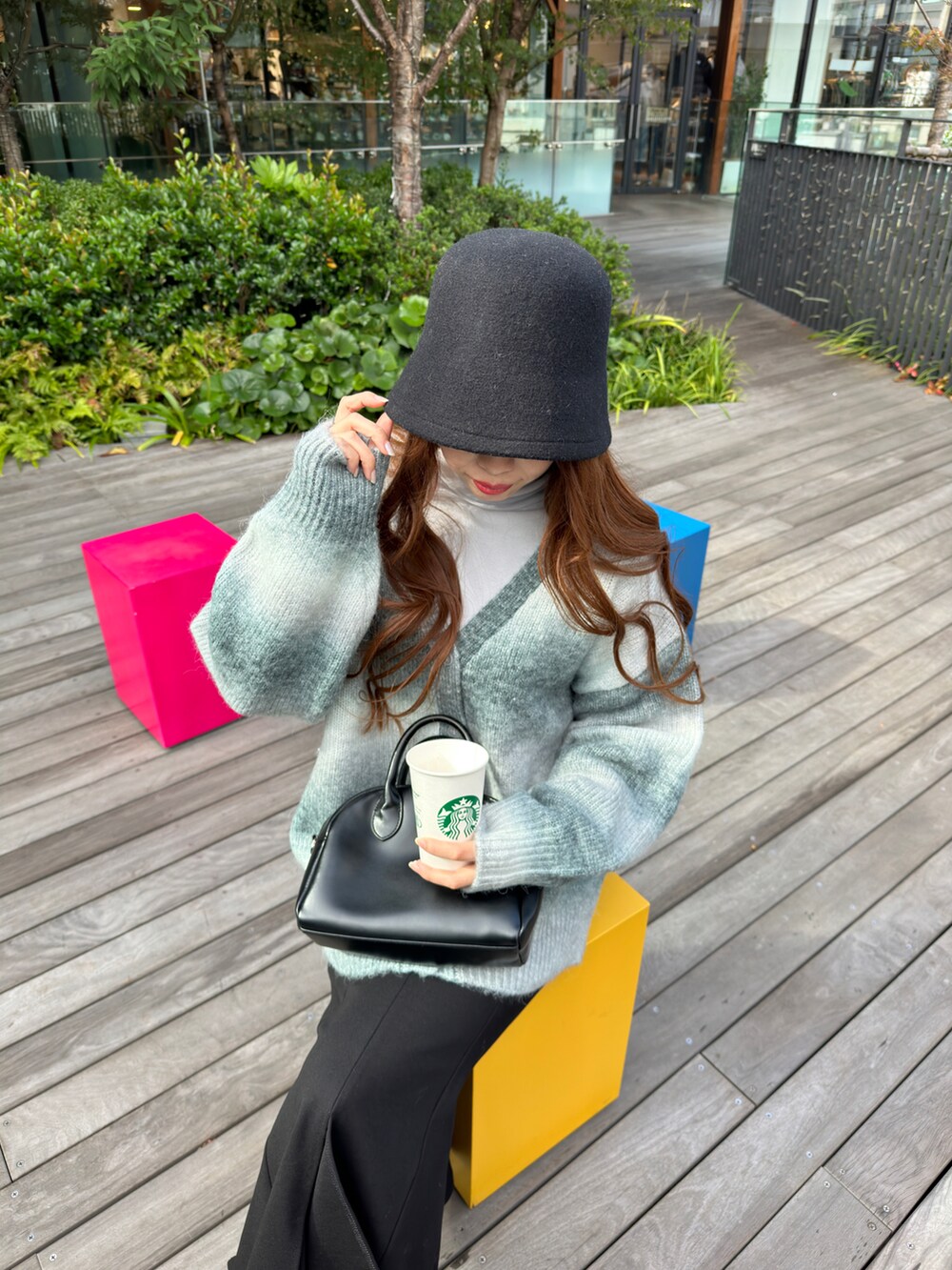 グレー系のTシャツ/カットソー、ブラック系のスカート、ブラック系のブーツを着用したレディースの冬コーディネートの5枚目の写真