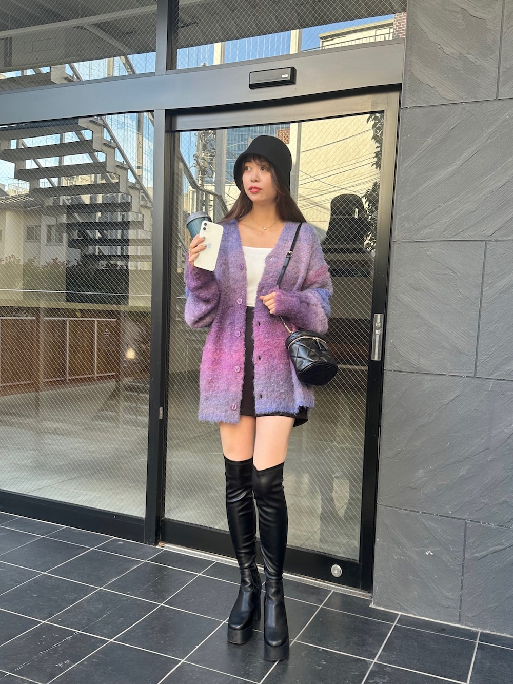 その他のカーディガン/ボレロ、ブラック系のブーツ、ベージュ系のハットを着用したレディースの冬コーディネートの2枚目の写真