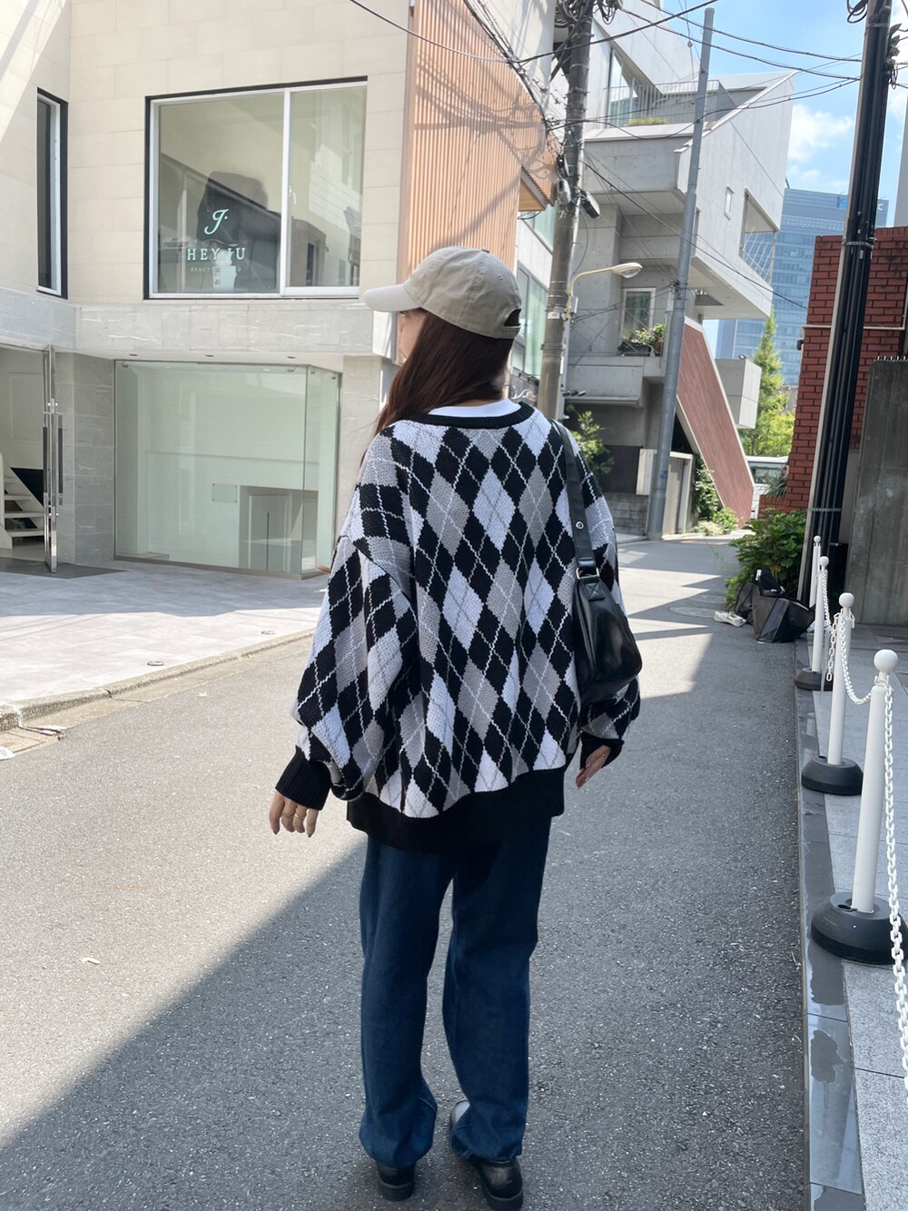 ブルー系のデニムパンツ、その他のカーディガン/ボレロ、ブラック系のショルダーバッグを着用したレディースの秋コーディネートの2枚目の写真