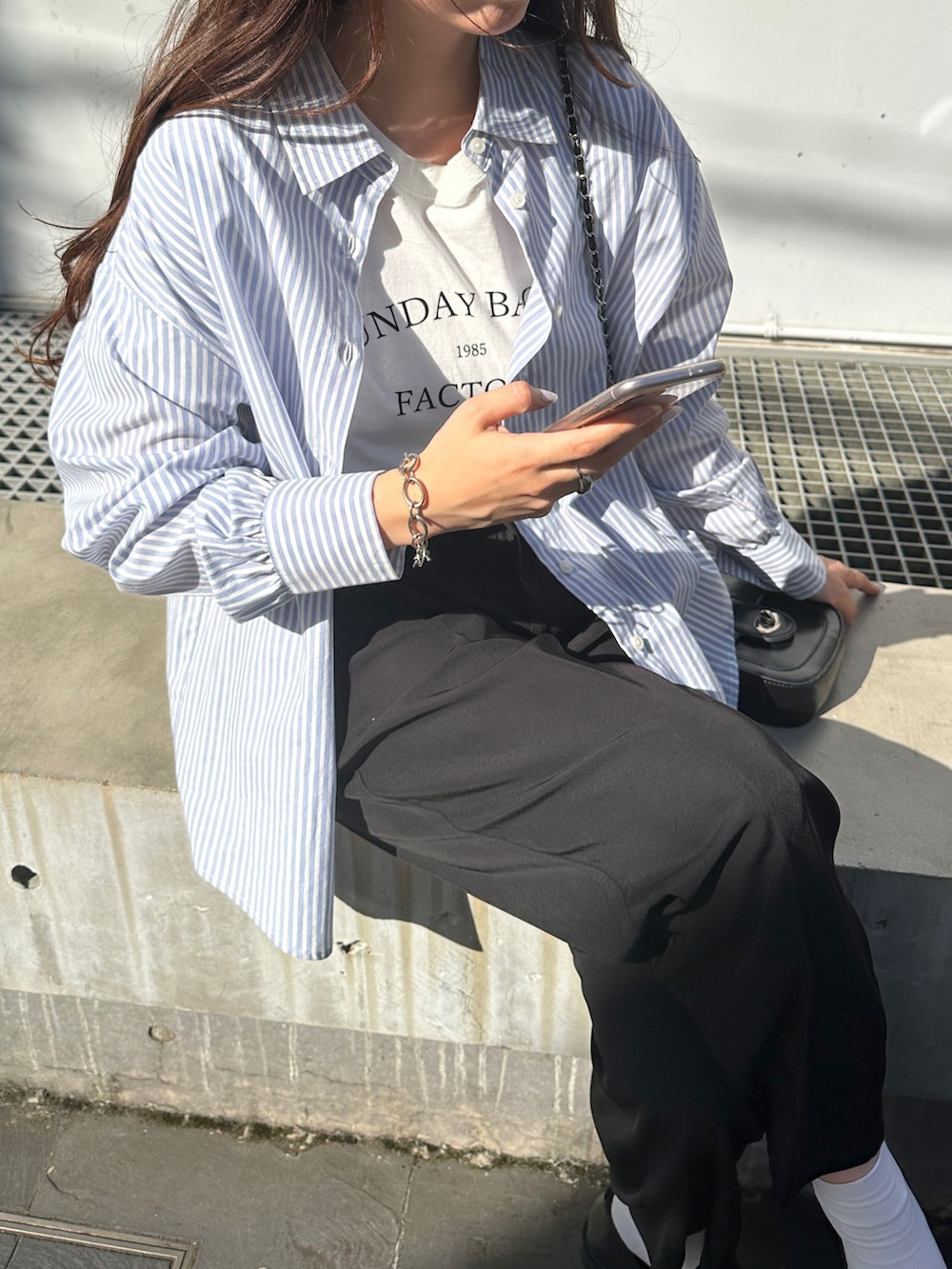 ブルー系のシャツ/ブラウス、ブラック系のスラックスを着用したレディースの春コーディネートの2枚目の写真