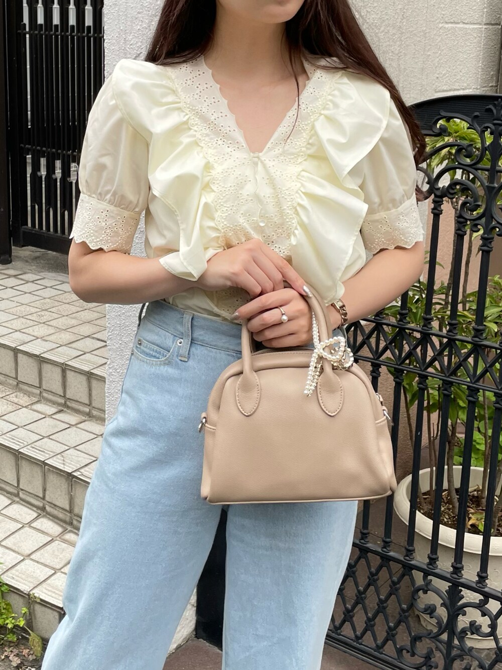 ブルー系のデニムパンツ、ホワイト系のサンダルを着用したレディースの夏コーディネートの4枚目の写真