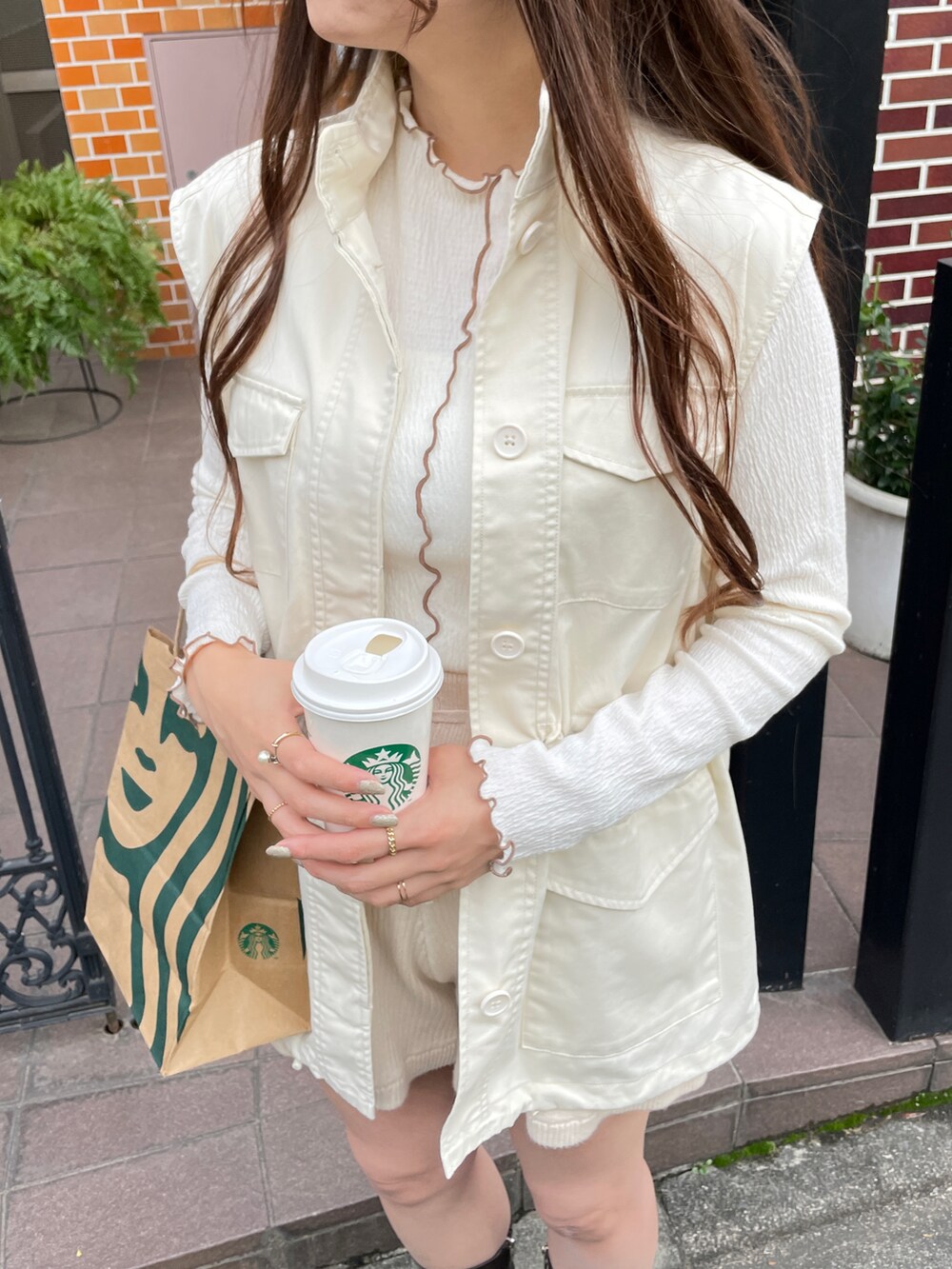 ホワイト系のベスト、ベージュ系のその他パンツを着用したレディースの冬コーディネートの2枚目の写真