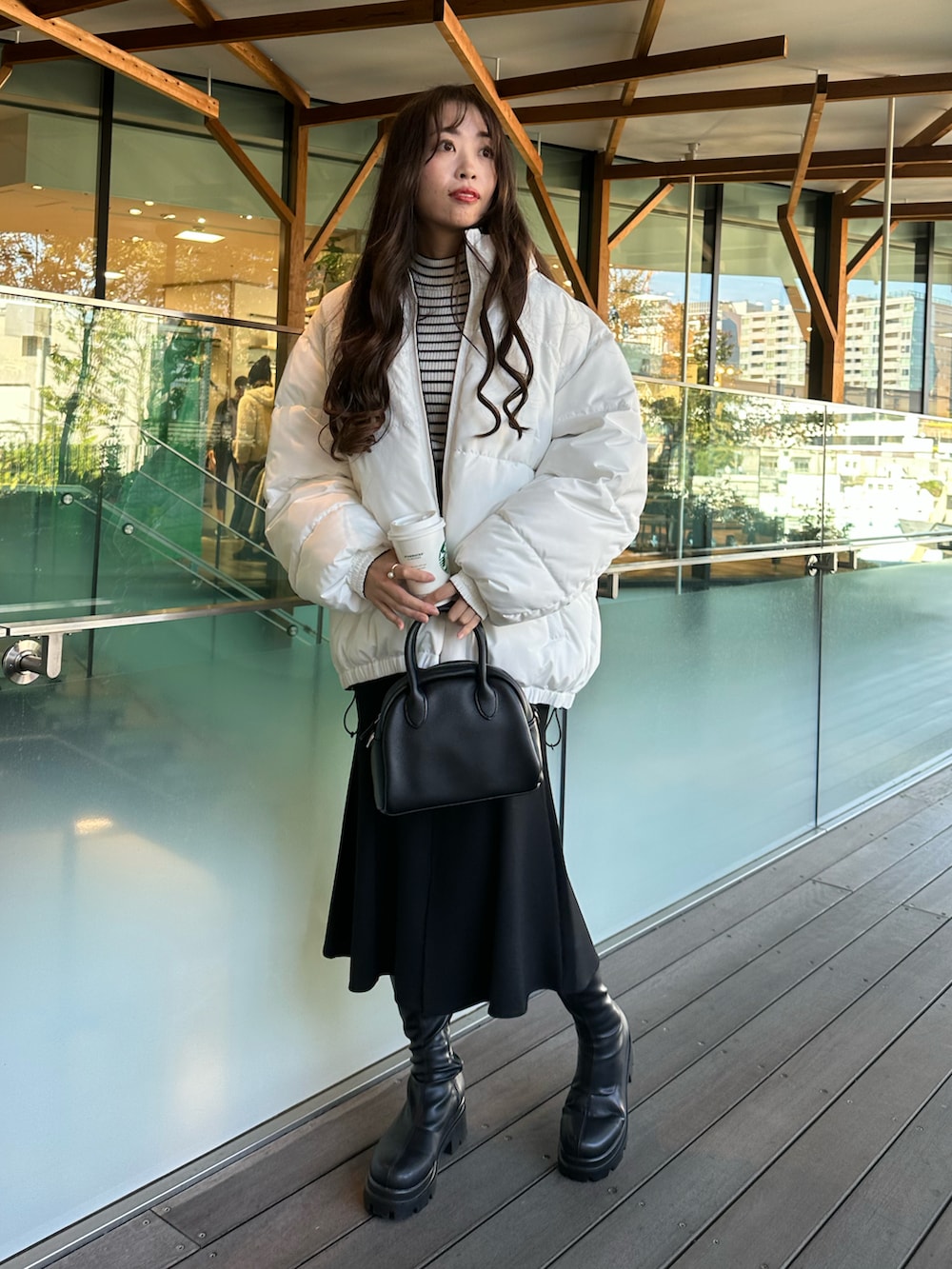 ホワイト系のダウンジャケット/コート、ブラック系のスカートを着用したレディースの秋コーディネートの5枚目の写真