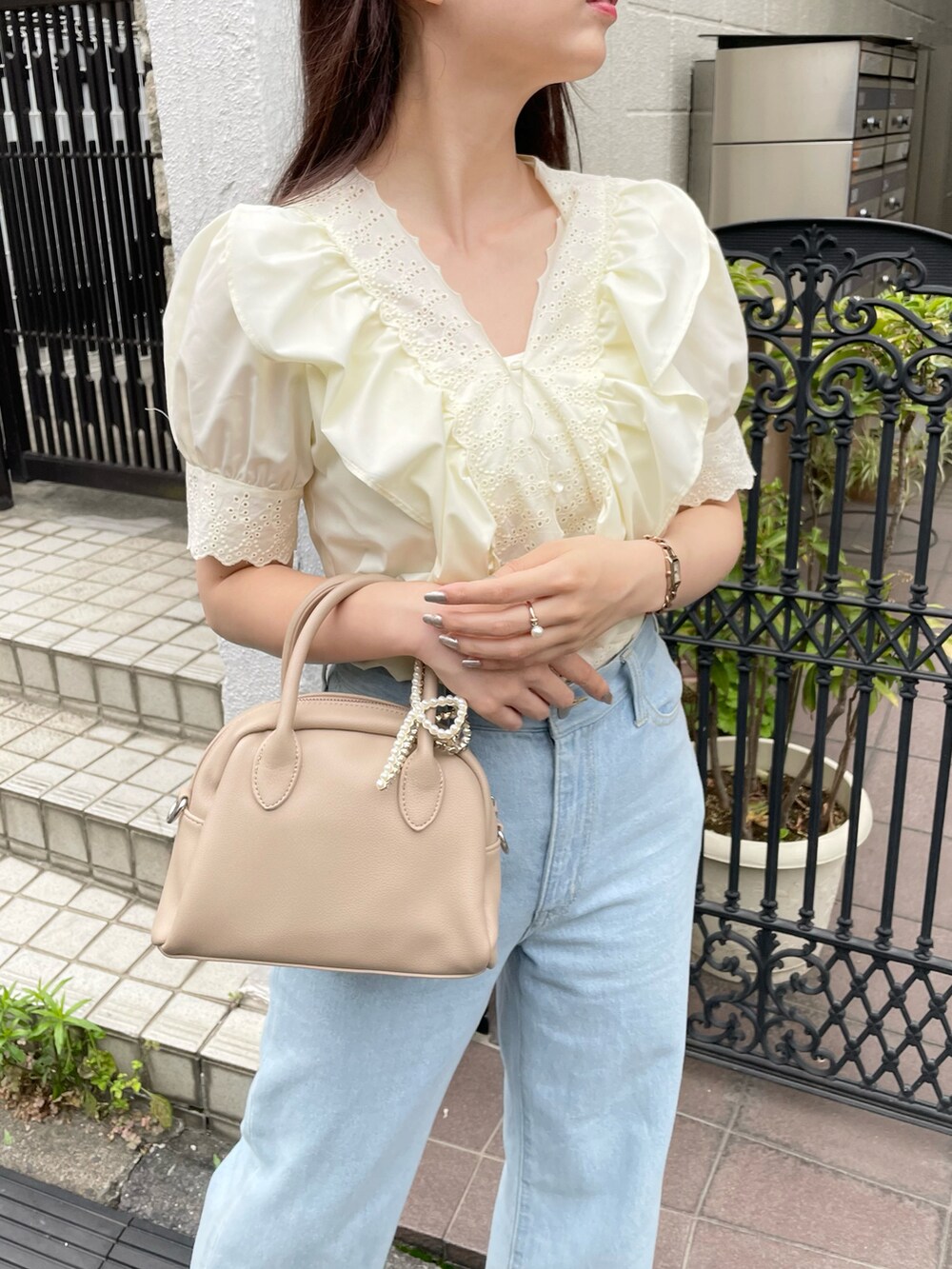 ブルー系のデニムパンツ、ホワイト系のサンダルを着用したレディースの夏コーディネートの3枚目の写真