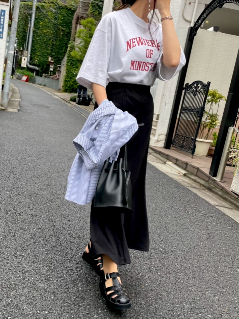 グレー系のTシャツ/カットソー、ブラック系のサンダル、ブラック系のスカートを着用したレディースの夏コーディネートの2枚目の写真