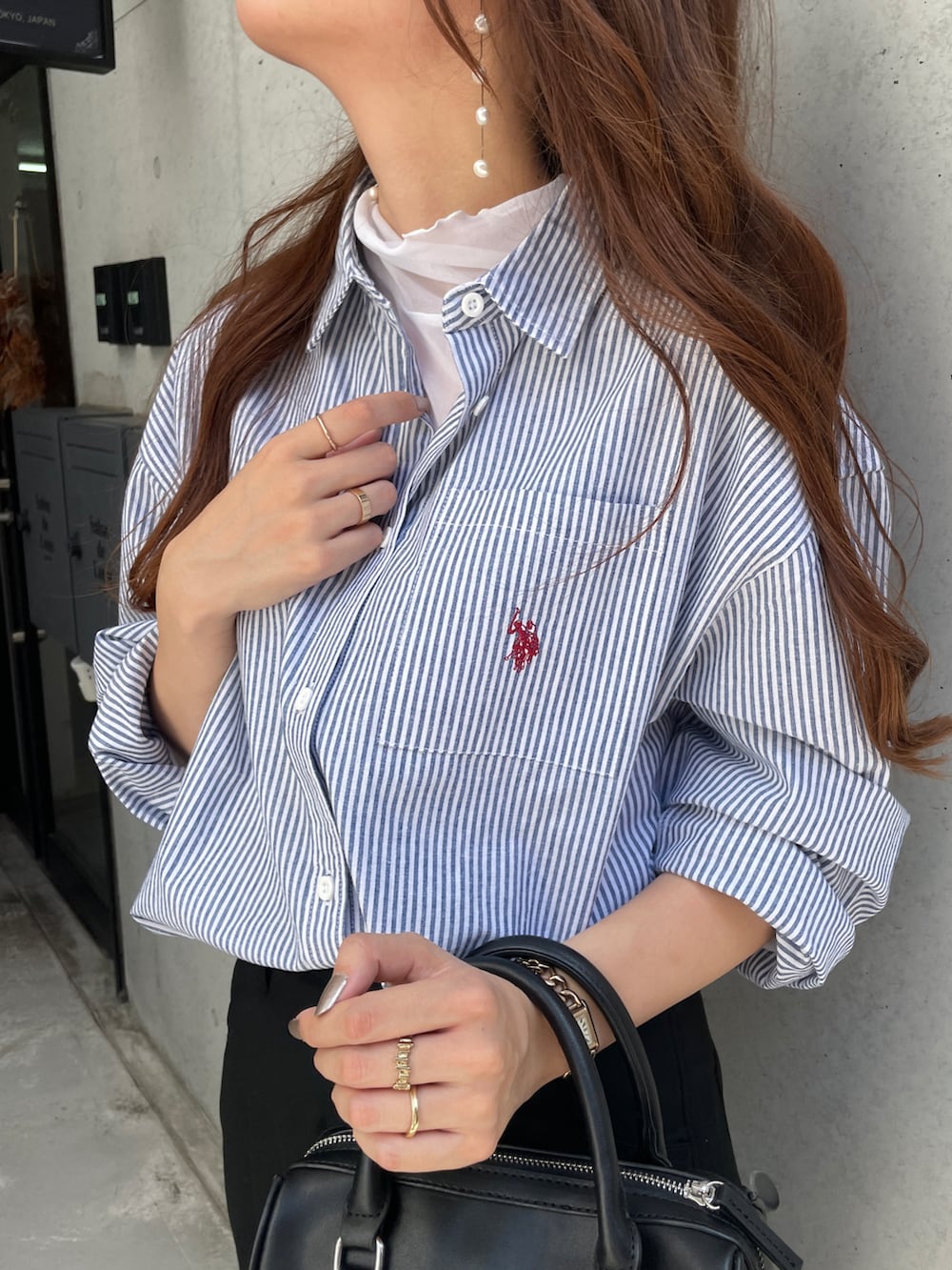 ホワイト系のTシャツ/カットソー、ブルー系のシャツ/ブラウス、ブラック系のボストンバッグを着用したレディースの秋コーディネートの2枚目の写真
