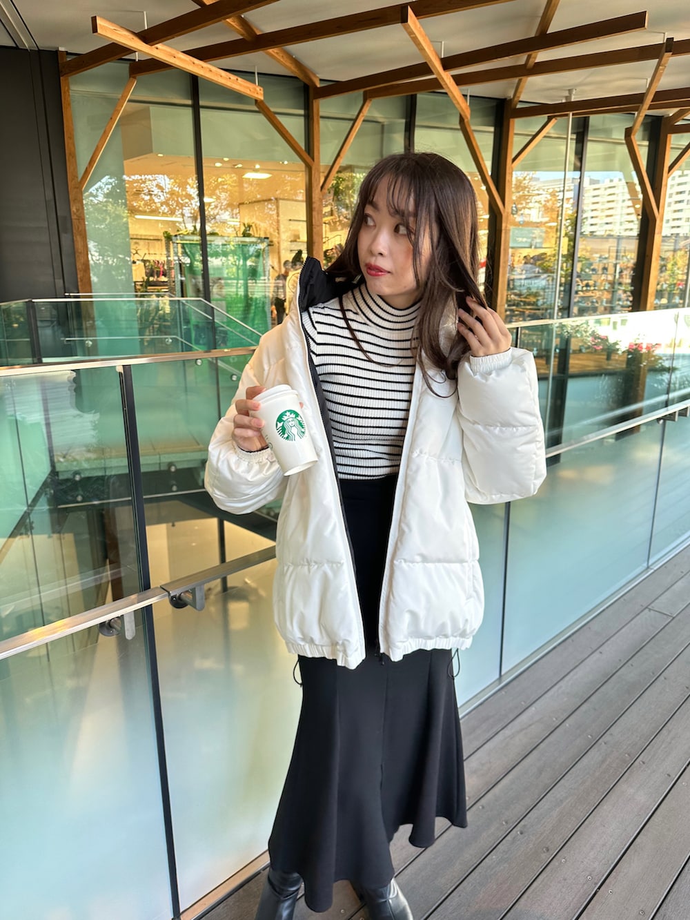ホワイト系のダウンジャケット/コート、ブラック系のスカートを着用したレディースの秋コーディネートの2枚目の写真
