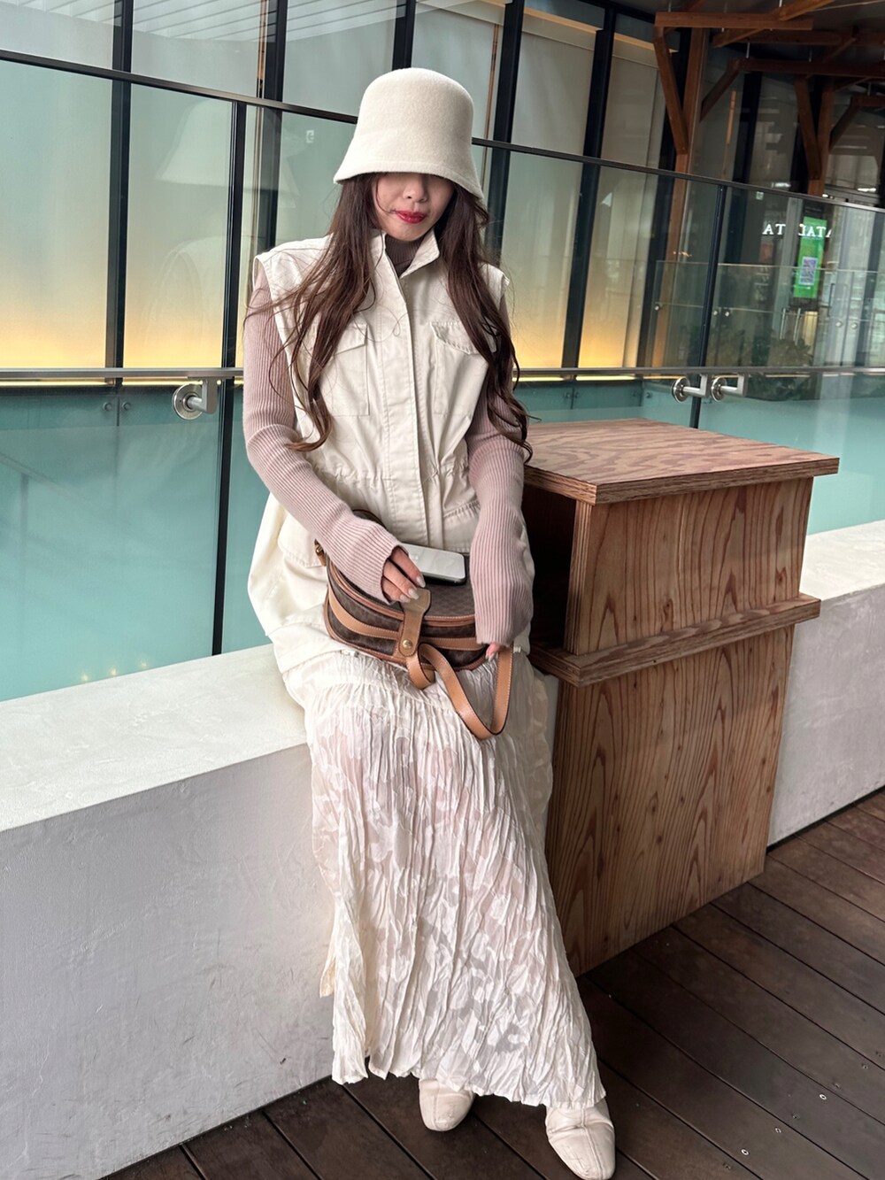 ホワイト系のベスト、その他のワンピース、ブラウン系のニット/セーターを着用したレディースの冬コーディネートの2枚目の写真