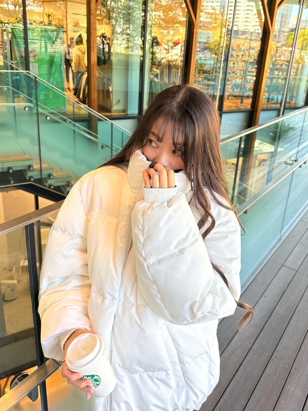 ホワイト系のダウンジャケット/コート、ブラック系のスカートを着用したレディースの秋コーディネートの3枚目の写真