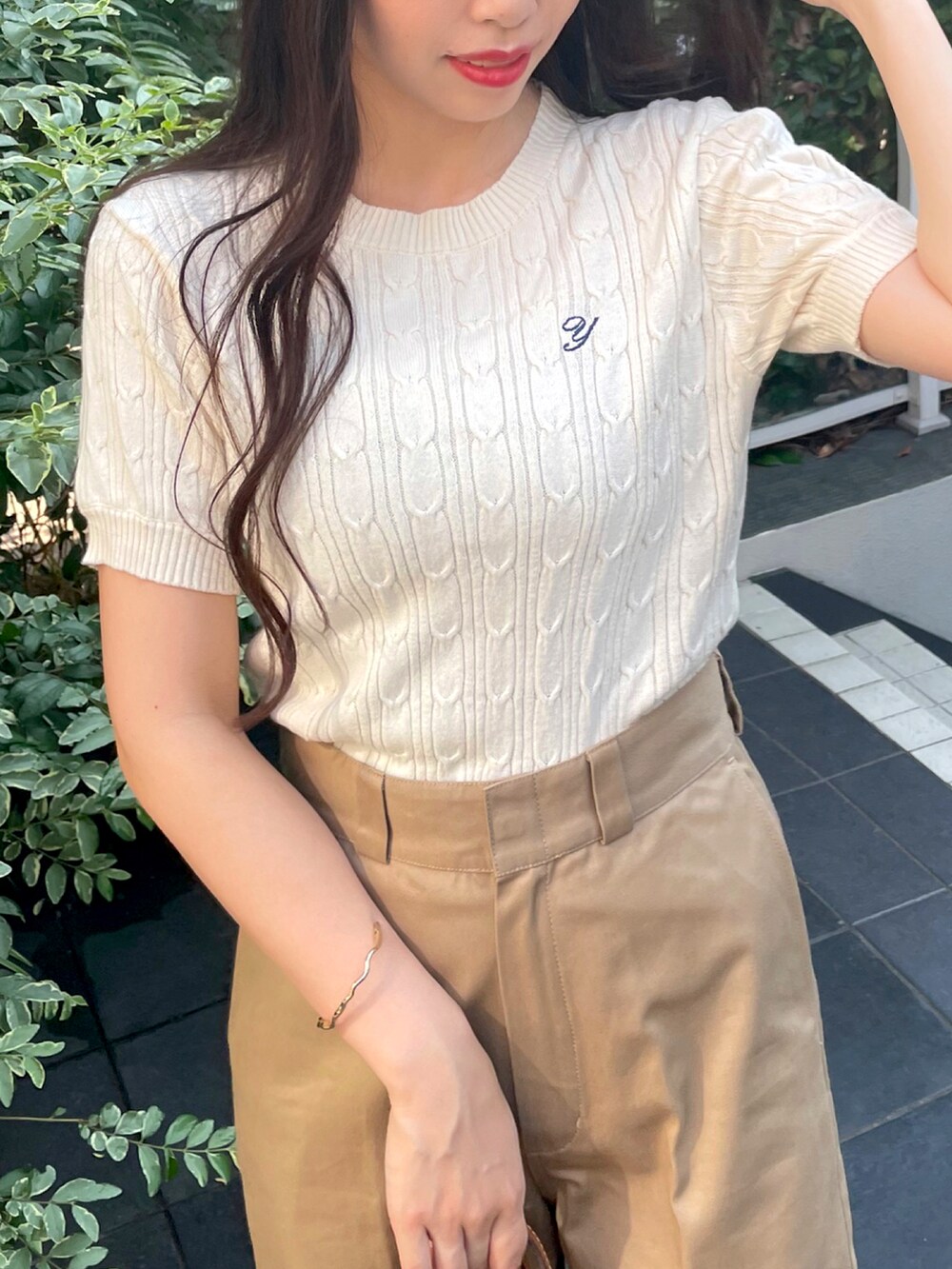 ベージュ系のチノパンツ、ホワイト系のニット/セーターを着用したレディースの夏コーディネートの3枚目の写真