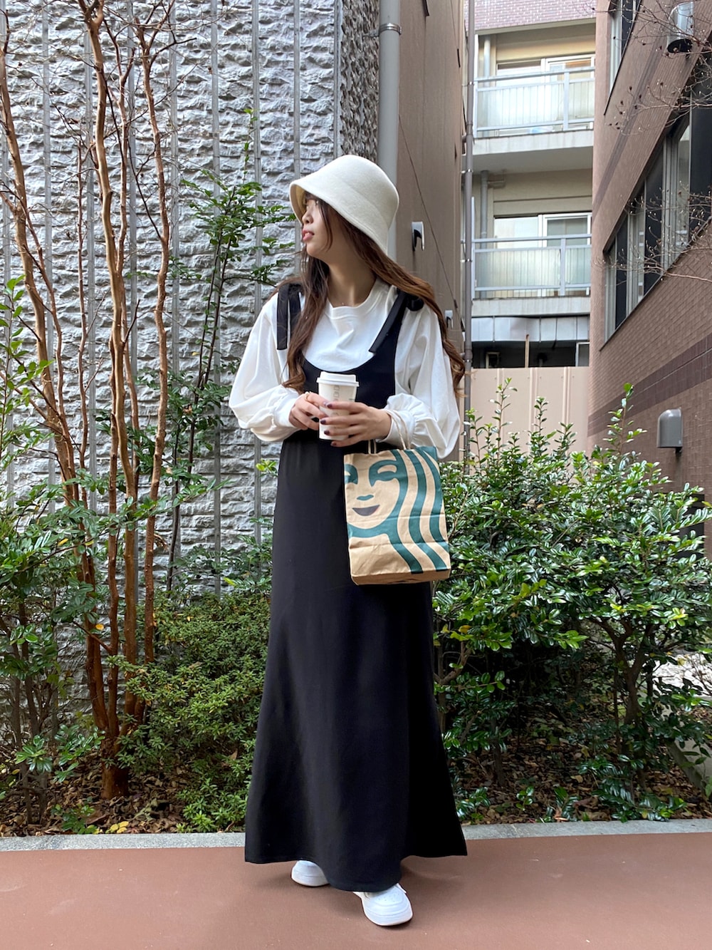 ブラック系のワンピース、ホワイト系のハットを着用したレディースの冬コーディネートの2枚目の写真