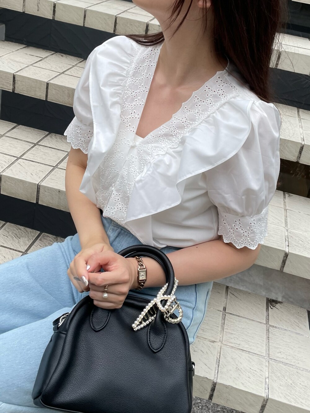 ブルー系のデニムパンツ、ホワイト系のサンダルを着用したレディースの夏コーディネートの4枚目の写真