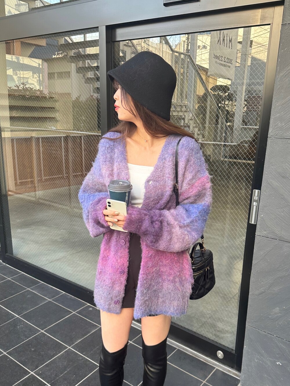 その他のカーディガン/ボレロ、ブラック系のブーツ、ベージュ系のハットを着用したレディースの冬コーディネートの4枚目の写真