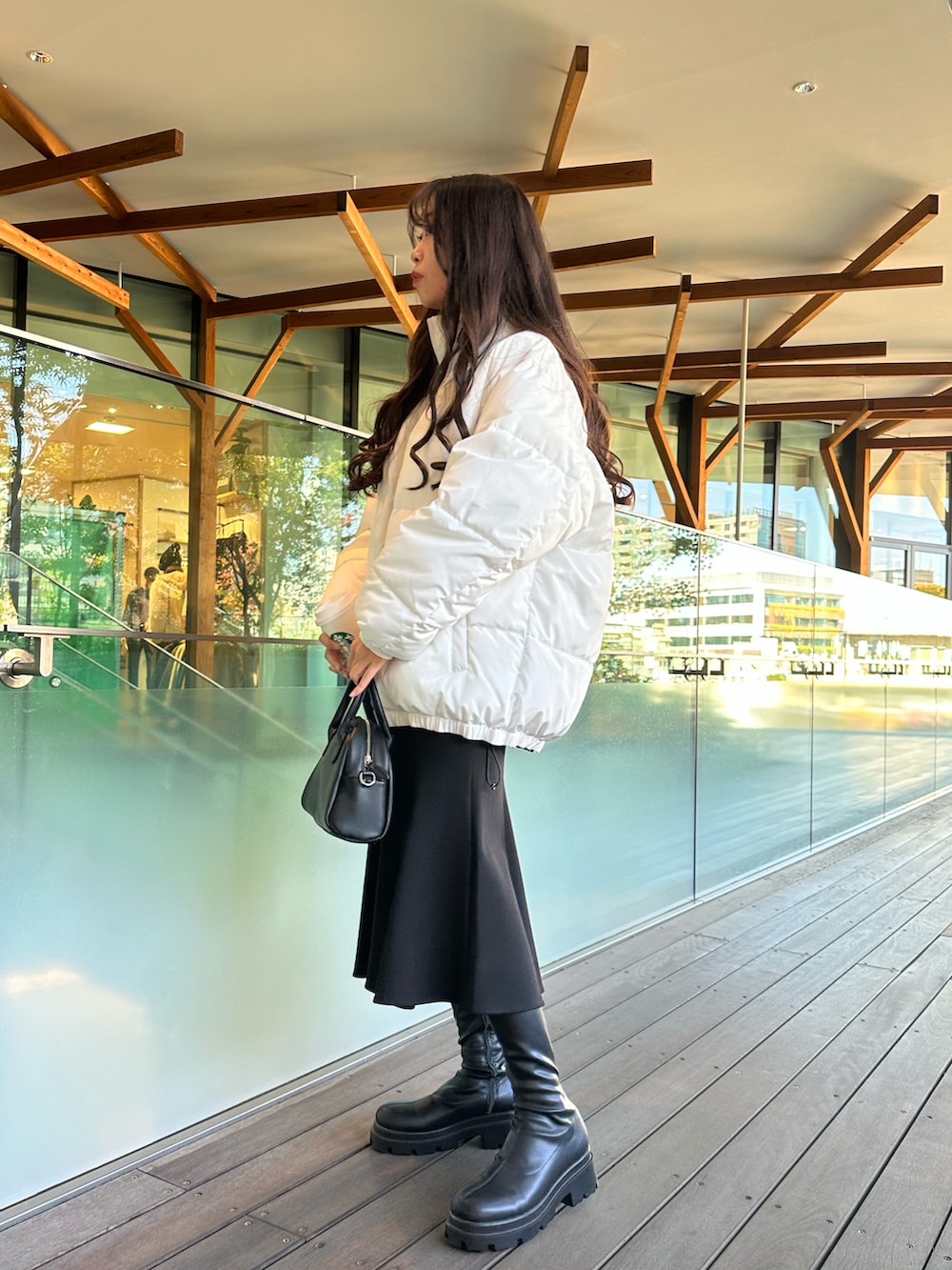 ホワイト系のダウンジャケット/コート、ブラック系のスカートを着用したレディースの秋コーディネートの4枚目の写真