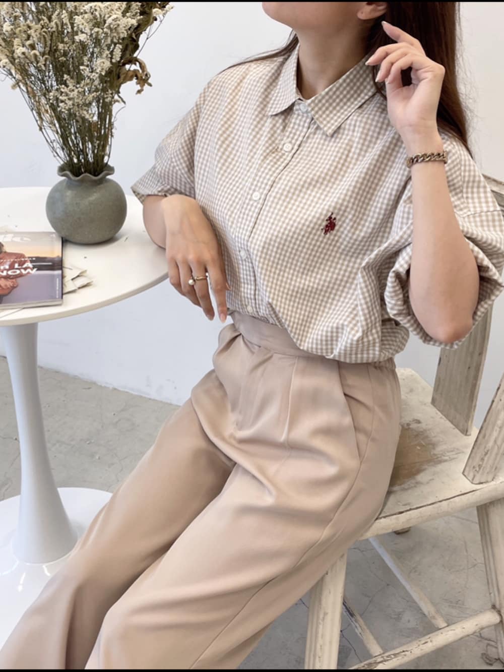 ベージュ系のシャツ/ブラウス、ベージュ系のスラックスを着用したレディースの夏コーディネートの2枚目の写真