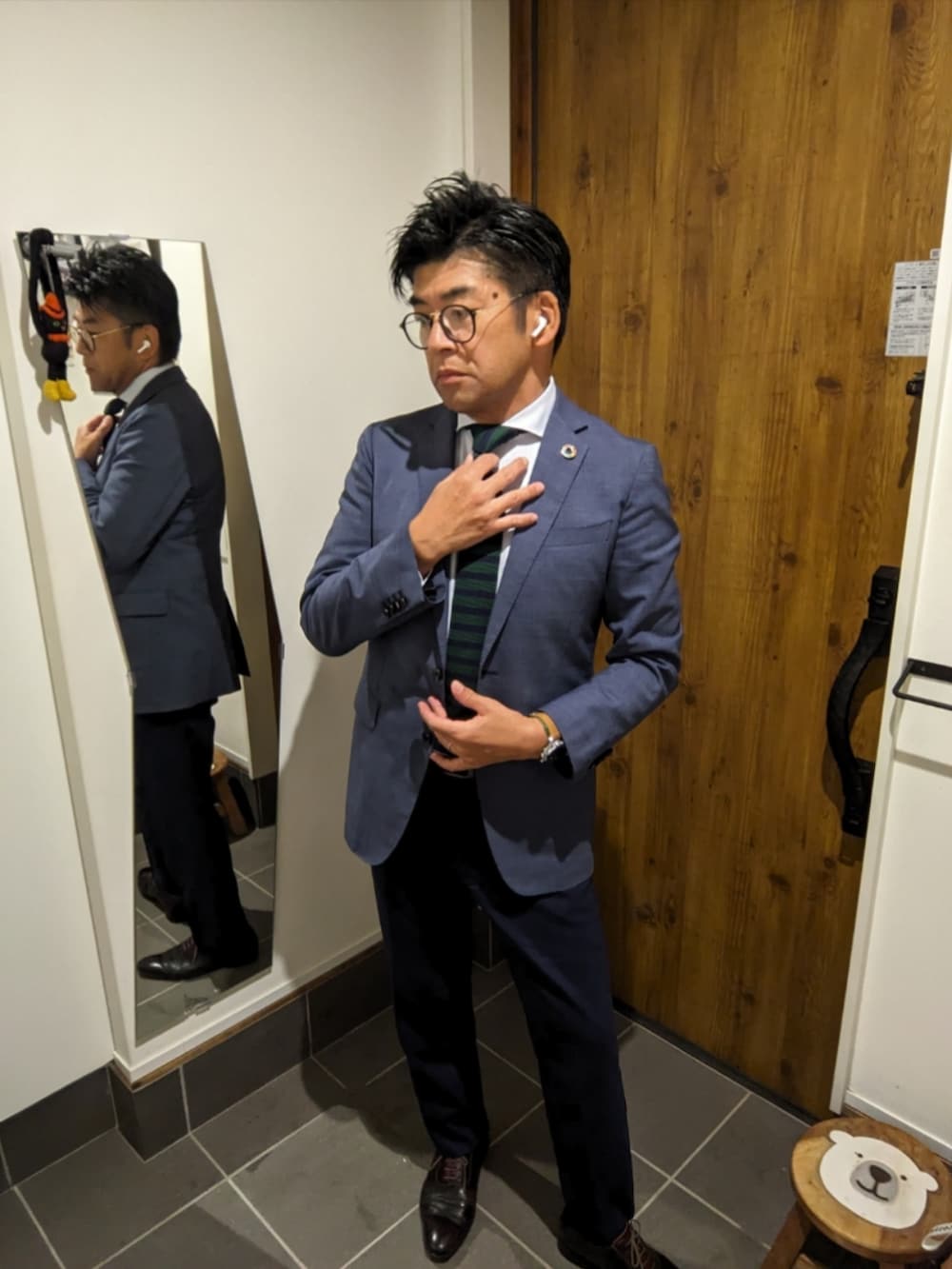 ブルー系のスーツジャケット、ブルー系のビジネスシャツ、グリーン系のネクタイを着用したメンズの秋コーディネートの2枚目の写真