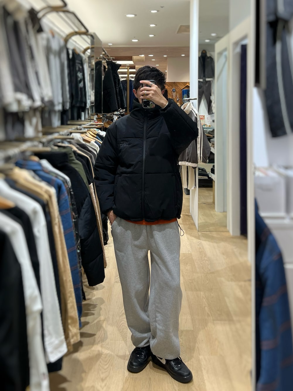 ブラック系のスニーカー、グレー系のスウェットパンツ、ブラック系のダウンジャケット/コートを着用したメンズの冬コーディネートの2枚目の写真