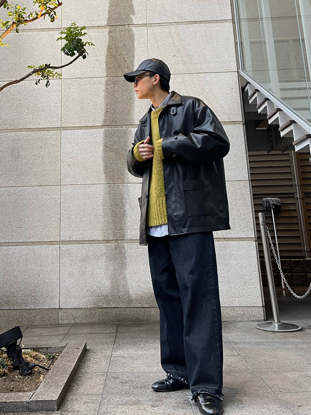 ブルー系のデニムパンツ、ブラック系のドレスシューズ、ブラック系のカバーオールを着用したメンズの冬コーディネートの2枚目の写真