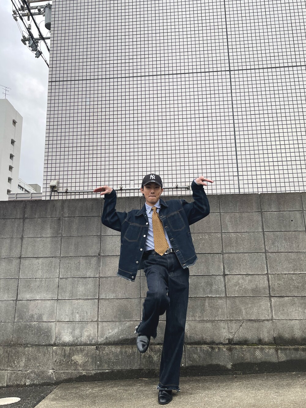 ブルー系のデニムジャケット、ブルー系のデニムパンツ、ブラック系のドレスシューズを着用したメンズの春コーディネートの4枚目の写真