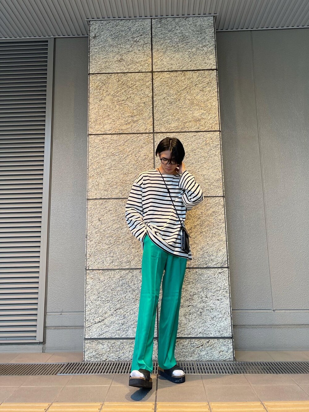 ホワイト系のTシャツ/カットソー、その他のショルダーバッグ、グリーン系のスラックスを着用したメンズの春コーディネートの2枚目の写真