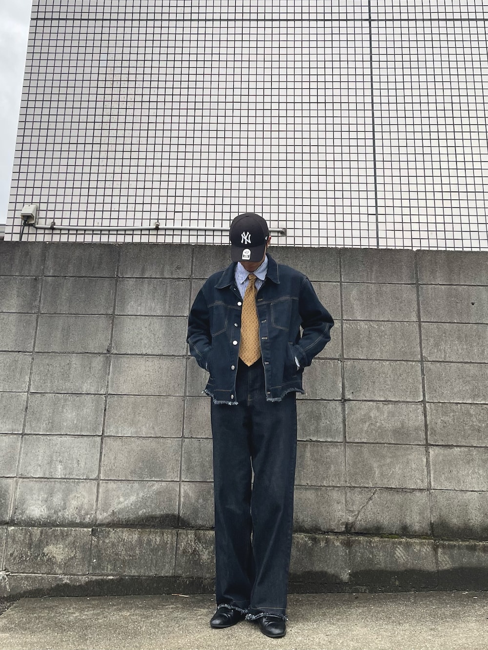 ブルー系のデニムジャケット、ブルー系のデニムパンツ、ブラック系のドレスシューズを着用したメンズの春コーディネートの2枚目の写真