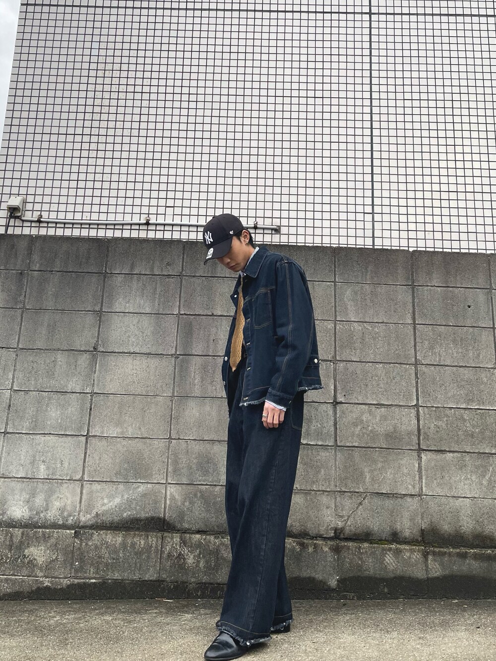 ブルー系のデニムジャケット、ブルー系のデニムパンツ、ブラック系のドレスシューズを着用したメンズの春コーディネートの3枚目の写真