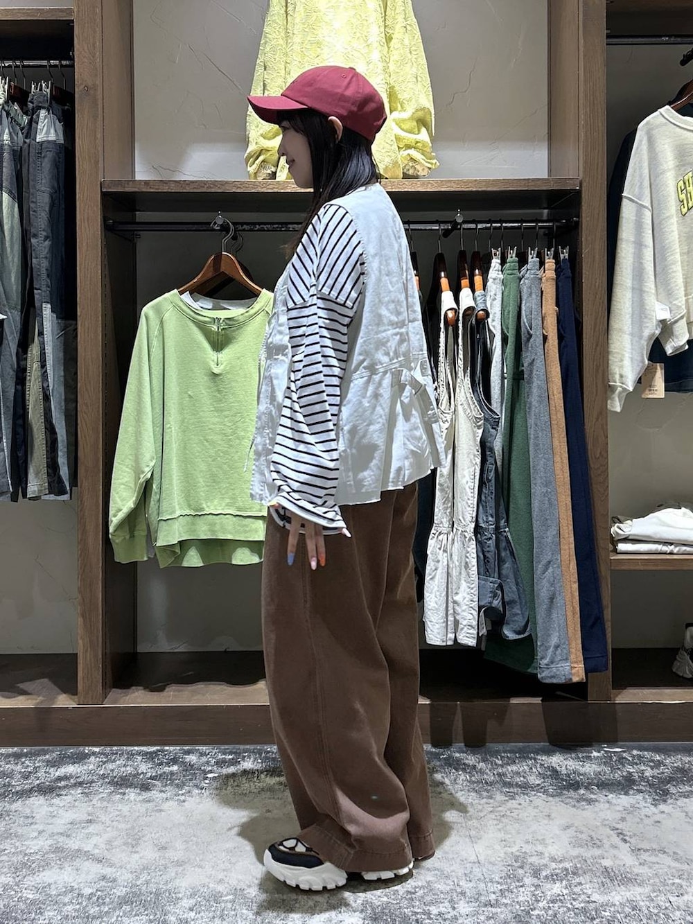 その他のスニーカー、ベージュ系のベスト、ブラック系のトートバッグを着用したレディースの春コーディネートの5枚目の写真