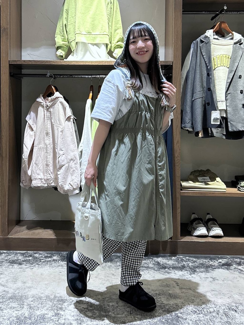 ホワイト系のその他パンツ、グリーン系のジャンパースカート、ブラック系のスニーカーを着用したレディースの春コーディネートの3枚目の写真