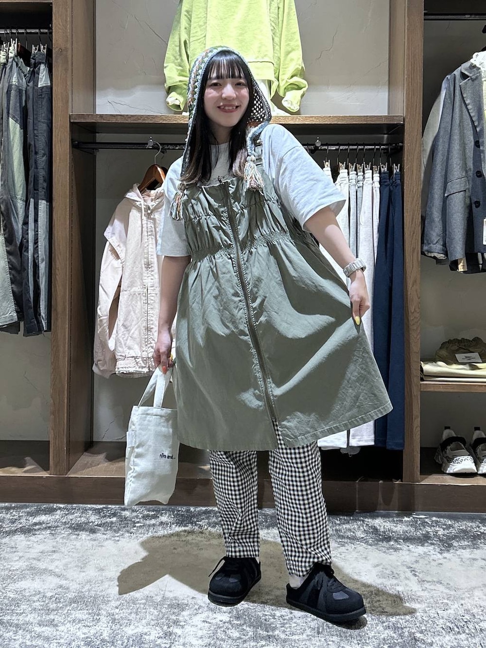 ホワイト系のその他パンツ、グリーン系のジャンパースカート、ブラック系のスニーカーを着用したレディースの春コーディネートの2枚目の写真