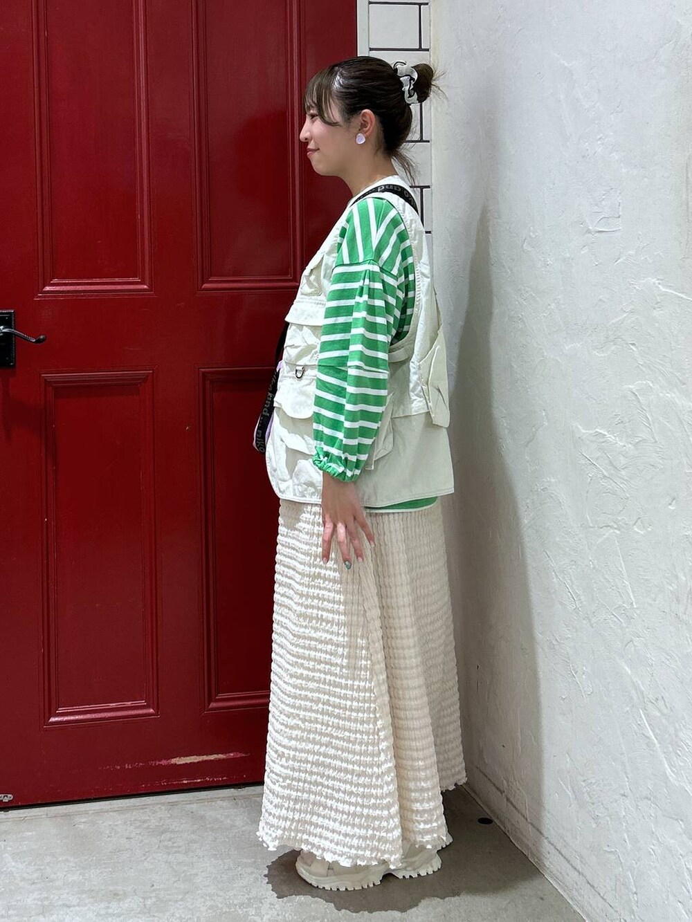 ベージュ系のサンダル、パープル系のショルダーバッグ、ベージュ系のベストを着用したレディースの春コーディネートの2枚目の写真