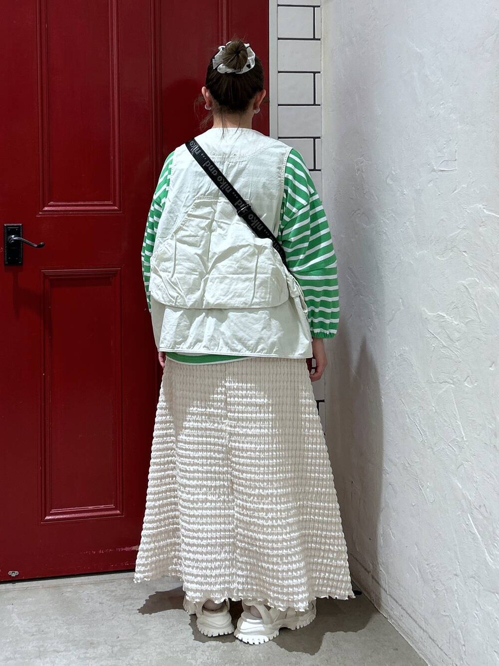 ベージュ系のサンダル、パープル系のショルダーバッグ、ベージュ系のベストを着用したレディースの春コーディネートの3枚目の写真