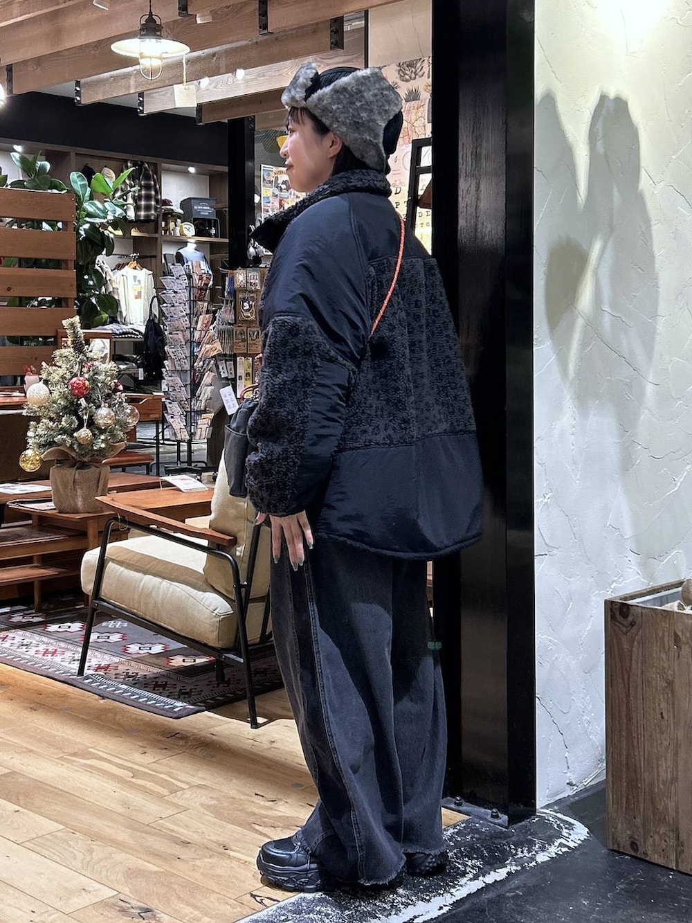 グレー系のその他アウター、ブラック系のデニムパンツ、ブラック系のスニーカーを着用したレディースの秋コーディネートの2枚目の写真