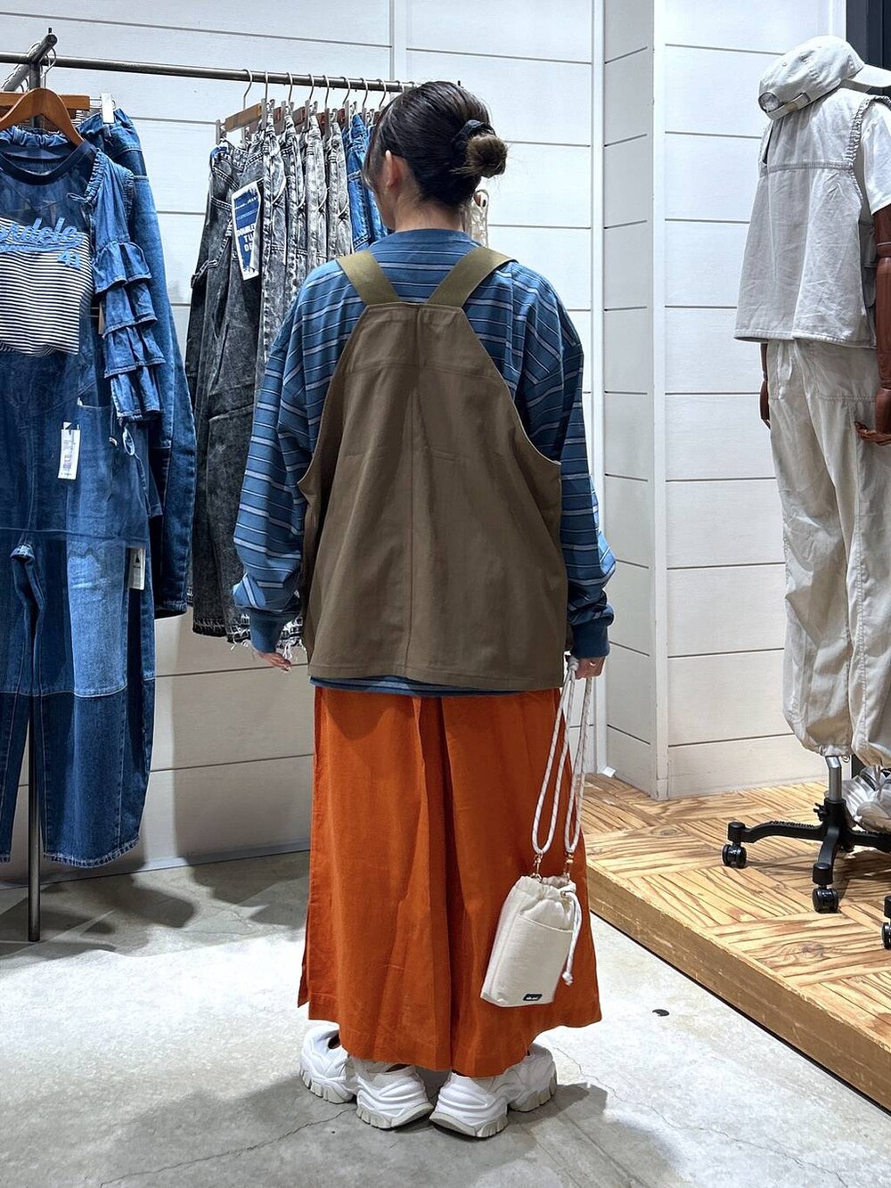 ホワイト系のショルダーバッグ、ブルー系のTシャツ/カットソー、ベージュ系のスニーカーを着用したレディースの秋コーディネートの3枚目の写真