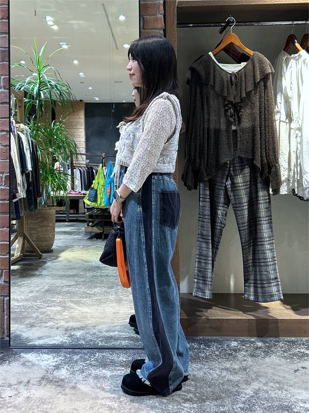 ホワイト系のTシャツ/カットソー、ホワイト系のベスト、ブラック系のトートバッグを着用したレディースの秋コーディネートの5枚目の写真