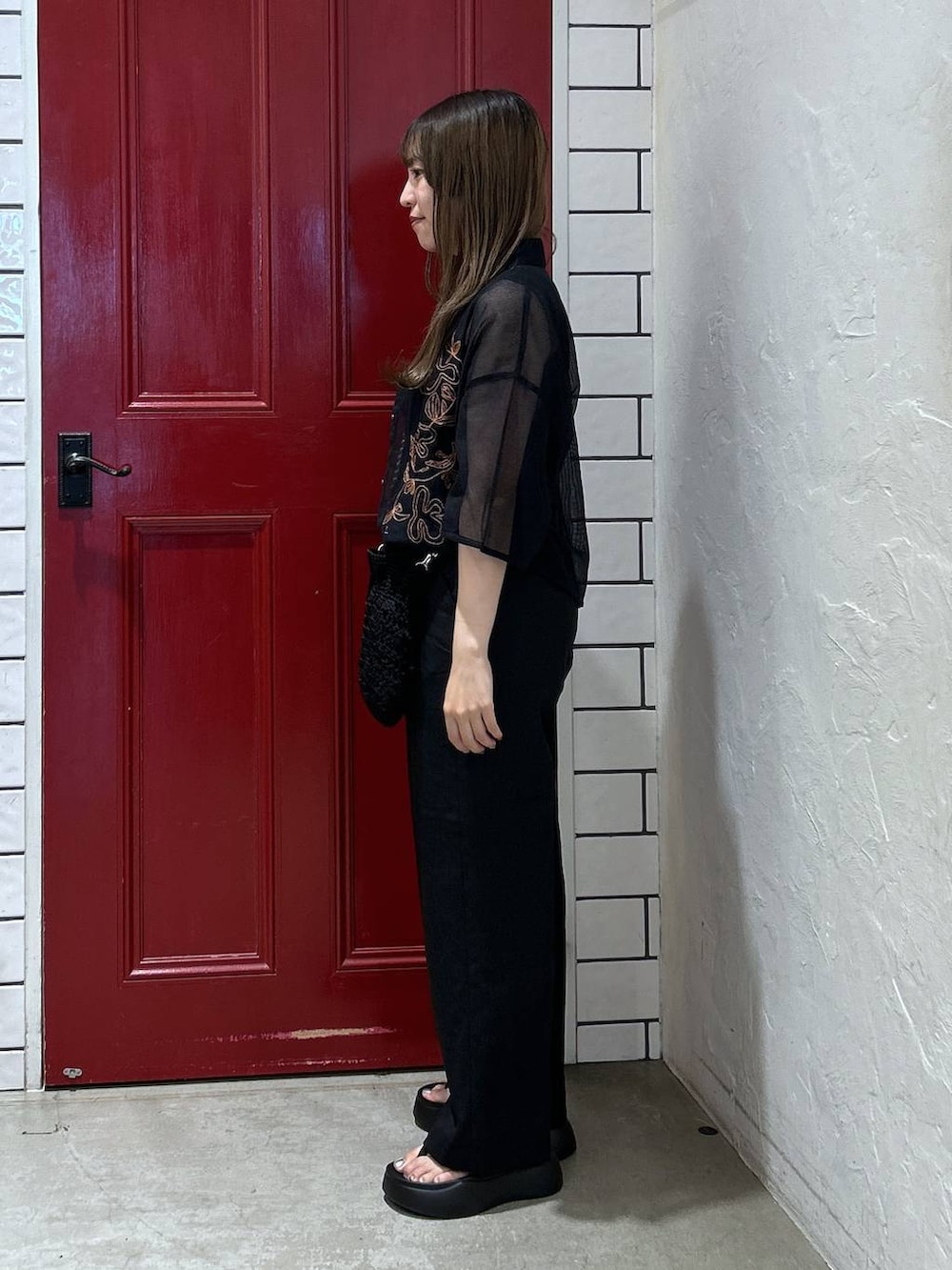 ブラック系のショルダーバッグ、ブラック系のサンダル、ブルー系のシャツ/ブラウスを着用したレディースの夏コーディネートの3枚目の写真