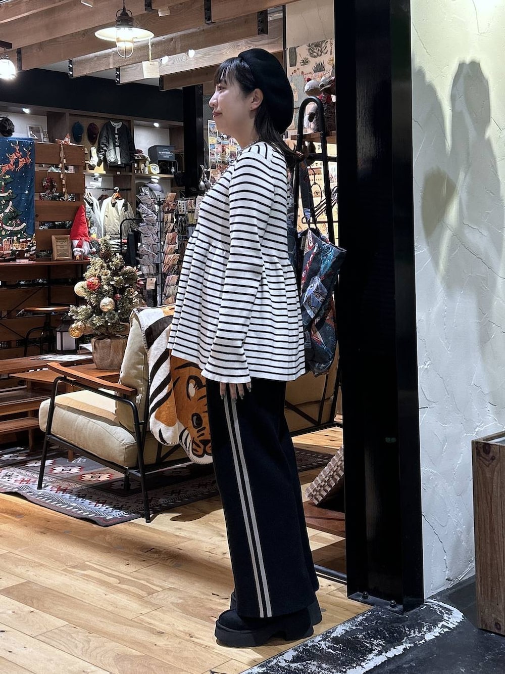 ブラック系のその他パンツ、ベージュ系のニット/セーター、ブラック系のブーツを着用したレディースの秋コーディネートの2枚目の写真