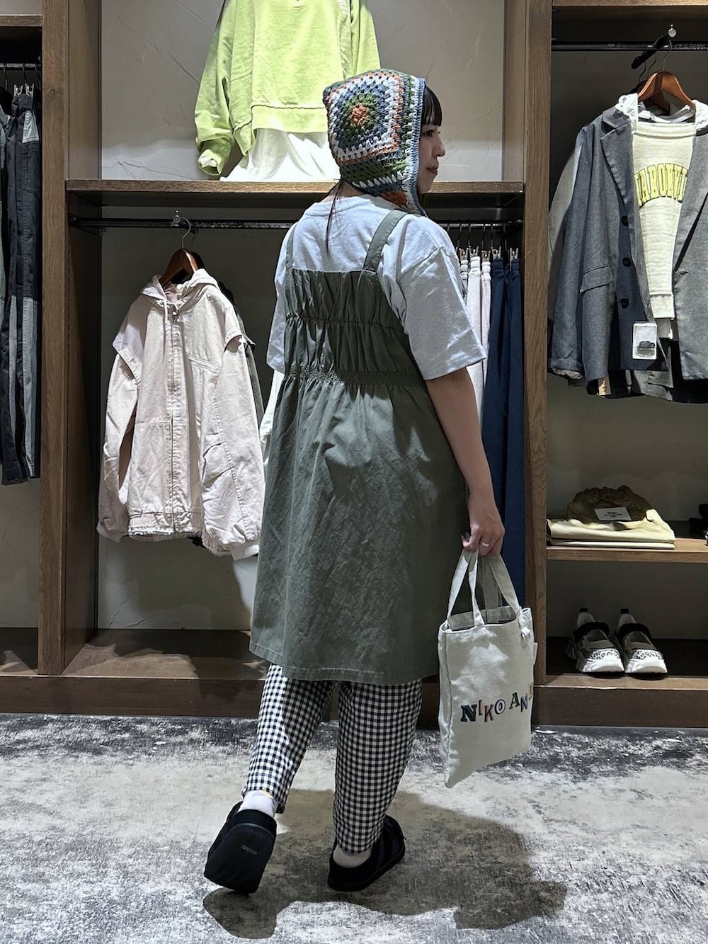 ホワイト系のその他パンツ、グリーン系のジャンパースカート、ブラック系のスニーカーを着用したレディースの春コーディネートの6枚目の写真