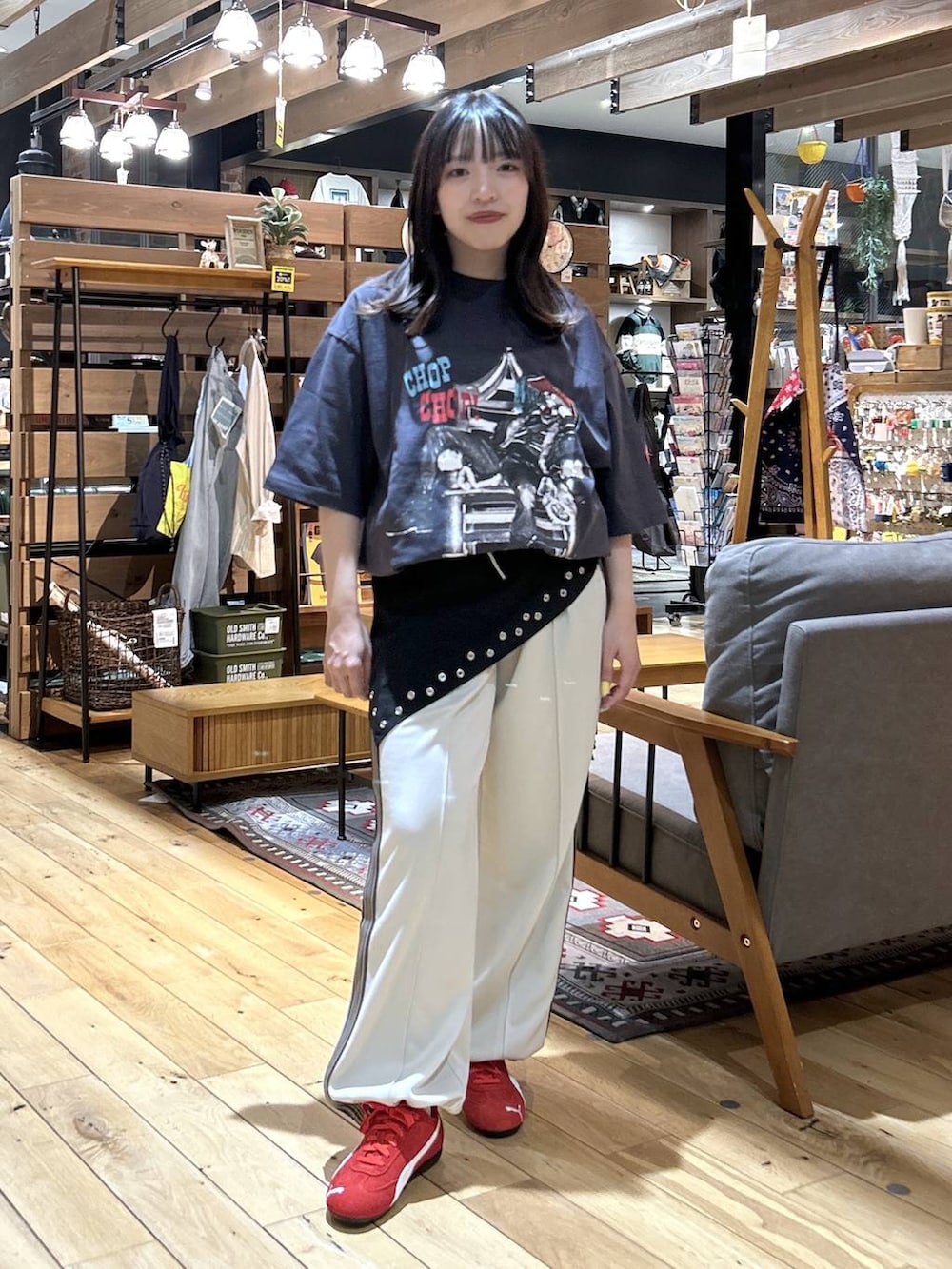 レッド系のスニーカー、ブラック系のショルダーバッグ、ベージュ系のカバーオールを着用したレディースの春コーディネートの5枚目の写真