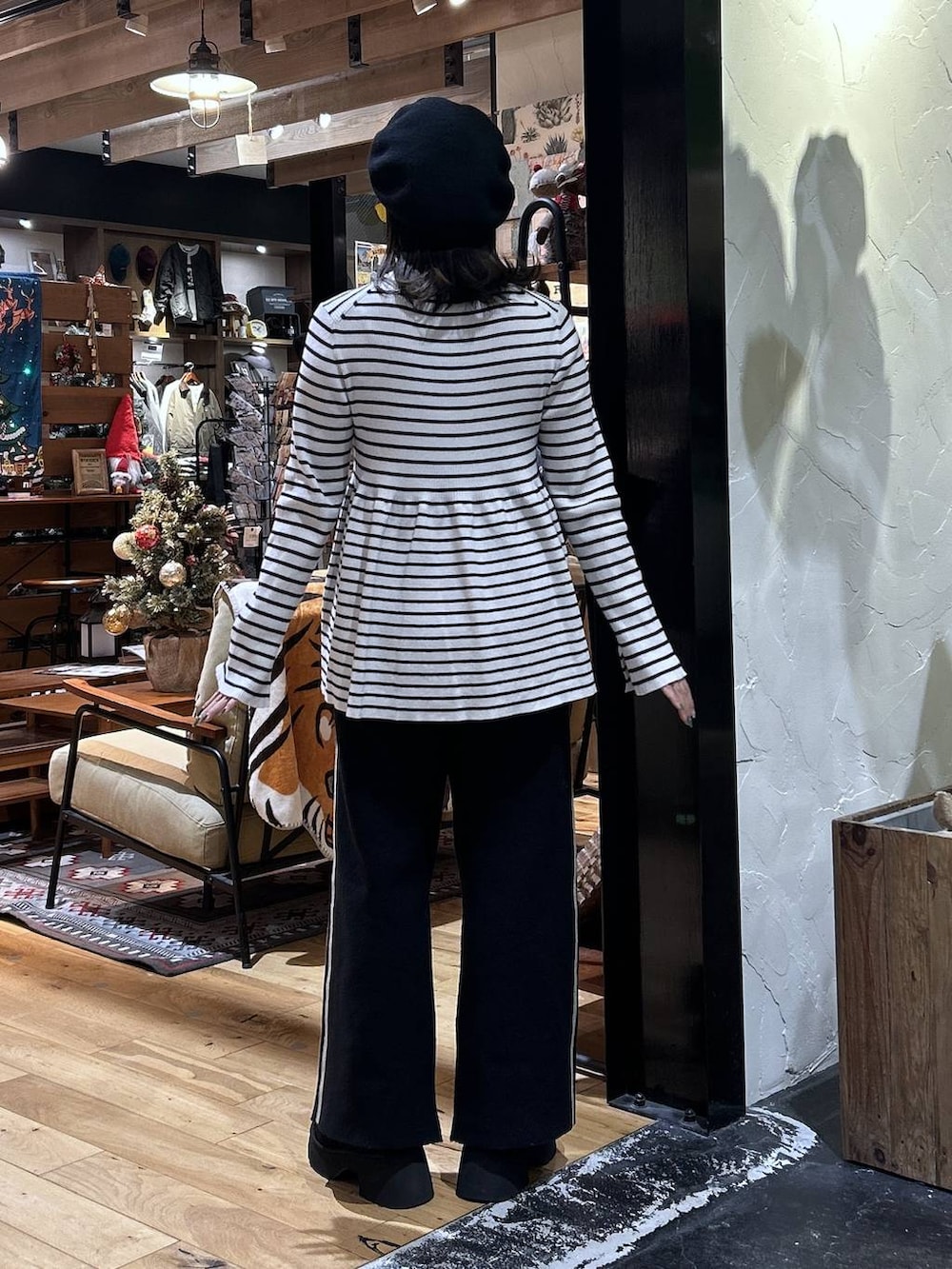 ブラック系のその他パンツ、ベージュ系のニット/セーター、ブラック系のブーツを着用したレディースの秋コーディネートの3枚目の写真