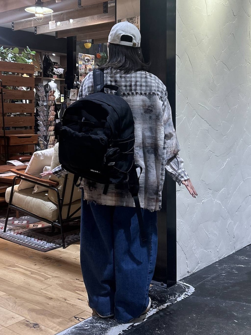 ブラウン系のシャツ/ブラウス、ベージュ系のスニーカー、グレー系のデニムパンツを着用したレディースの秋コーディネートの4枚目の写真