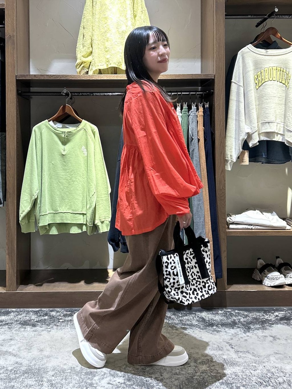 レッド系のシャツ/ブラウス、グレー系のタンクトップ、ベージュ系のスニーカーを着用したレディースの春コーディネートの3枚目の写真