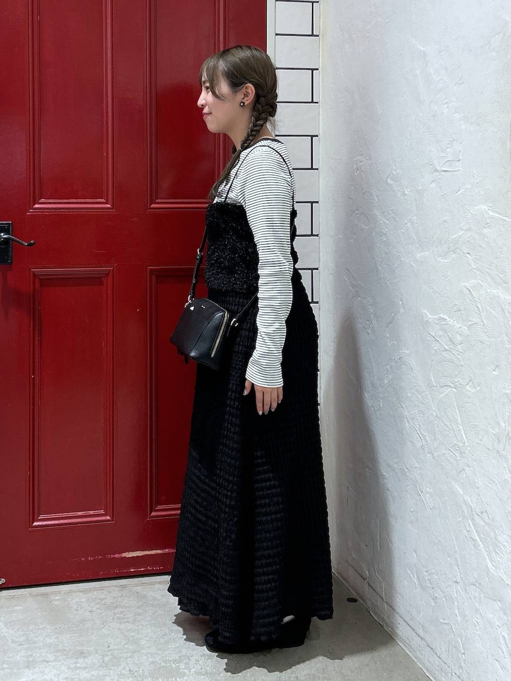 ブラック系のベスト、ベージュ系のTシャツ/カットソー、ブラック系のパンプスを着用したレディースの春コーディネートの2枚目の写真