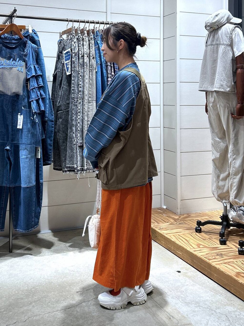 ホワイト系のショルダーバッグ、ブルー系のTシャツ/カットソー、ベージュ系のスニーカーを着用したレディースの秋コーディネートの2枚目の写真