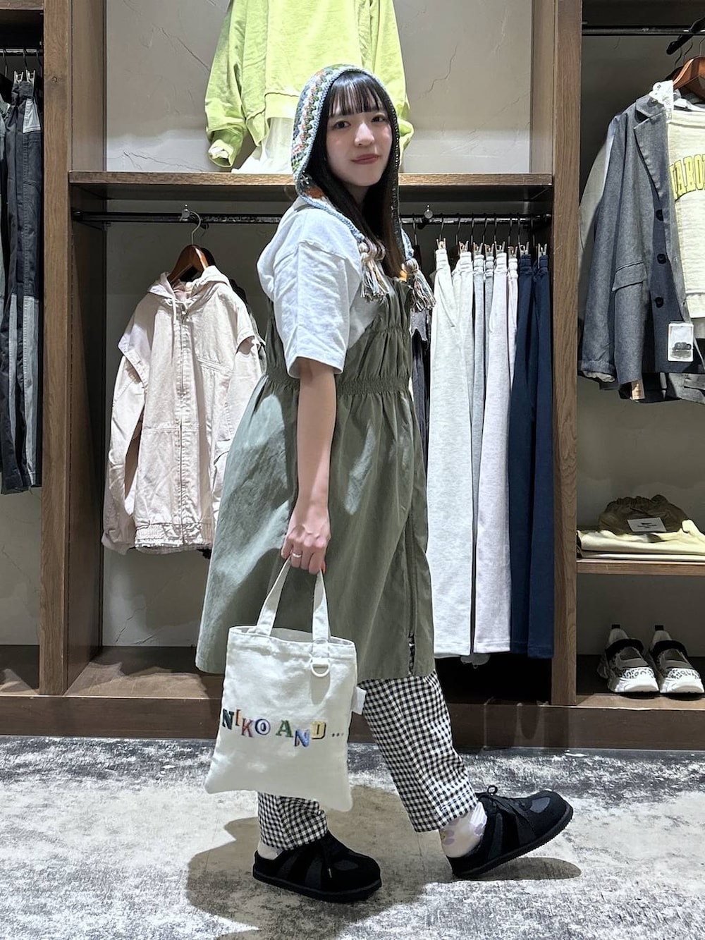 ホワイト系のその他パンツ、グリーン系のジャンパースカート、ブラック系のスニーカーを着用したレディースの春コーディネートの4枚目の写真