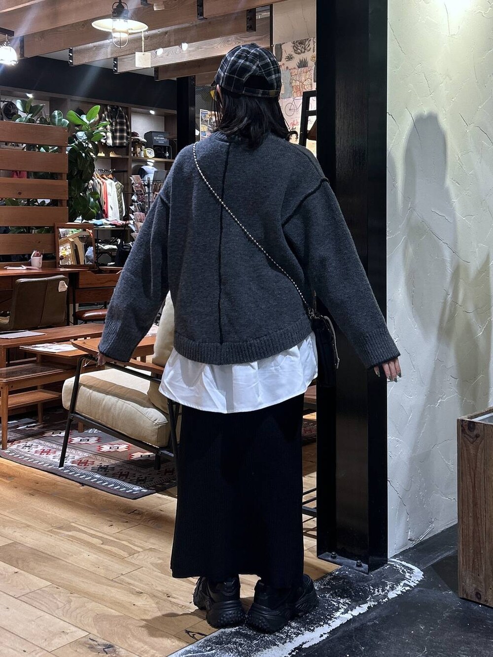 ブラック系のショルダーバッグ、ブラック系のスカート、ブラック系のスニーカーを着用したレディースの秋コーディネートの3枚目の写真