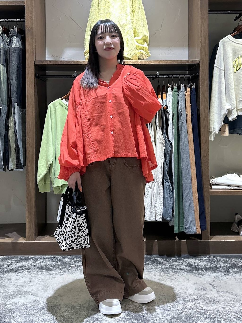 レッド系のシャツ/ブラウス、グレー系のタンクトップ、ベージュ系のスニーカーを着用したレディースの春コーディネートの2枚目の写真