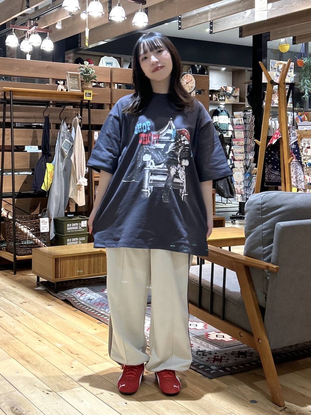 レッド系のスニーカー、ブラック系のショルダーバッグ、ベージュ系のカバーオールを着用したレディースの春コーディネートの6枚目の写真