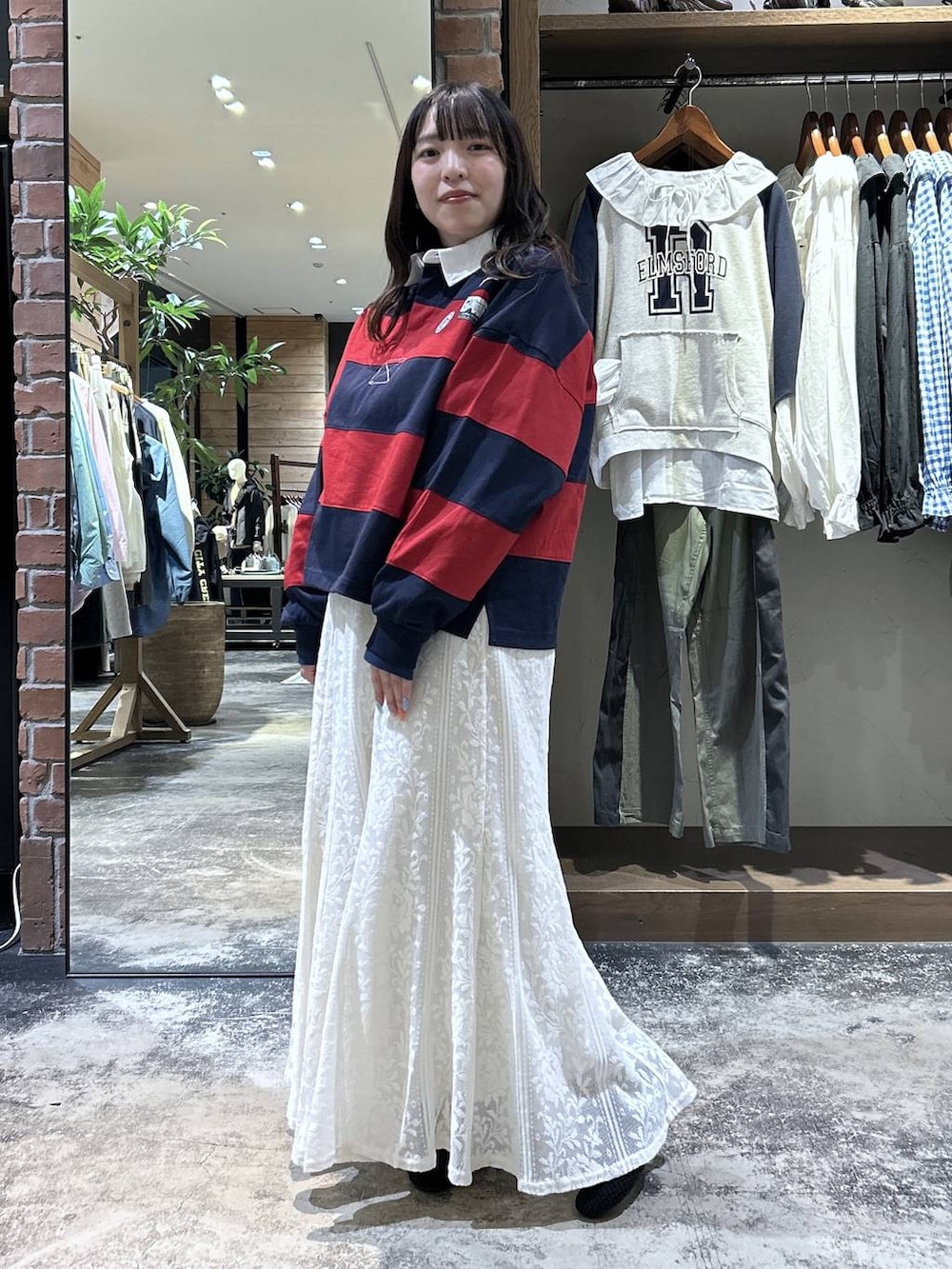 ブルー系のシャツ/ブラウス、ブラック系のパンプス、レッド系のTシャツ/カットソーを着用したレディースの春コーディネートの2枚目の写真