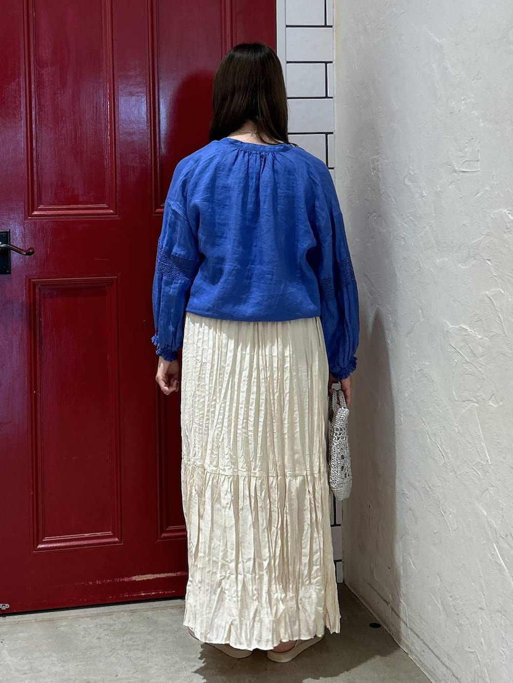 グレー系のショルダーバッグ、ベージュ系のスカート、ベージュ系のサンダルを着用したレディースの夏コーディネートの4枚目の写真